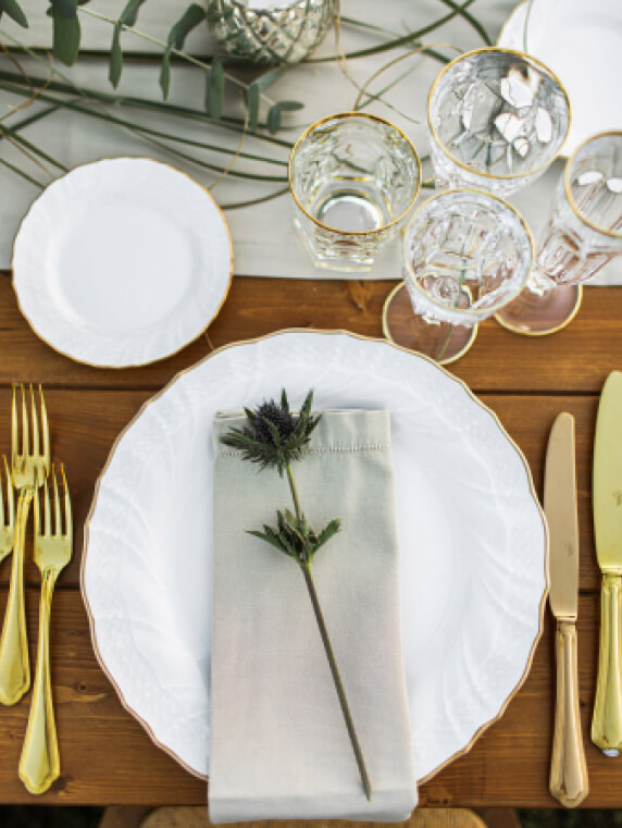 attractive table setting with white plate and gold silverware